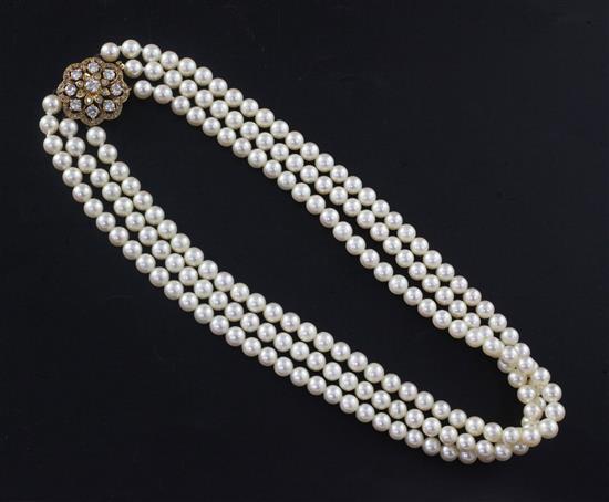 A 1980s triple strand cultured pearl choker necklace with 18ct gold and diamond cluster set clasp, 36cm.